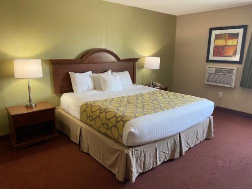 a hotel room with a large bed and two lamps at Baymont by Wyndham Kokomo in Kokomo