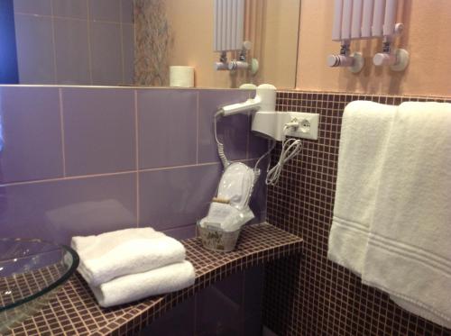 a bathroom with towels and a hair dryer on a shelf at Corte Del Gallo in Corniglia