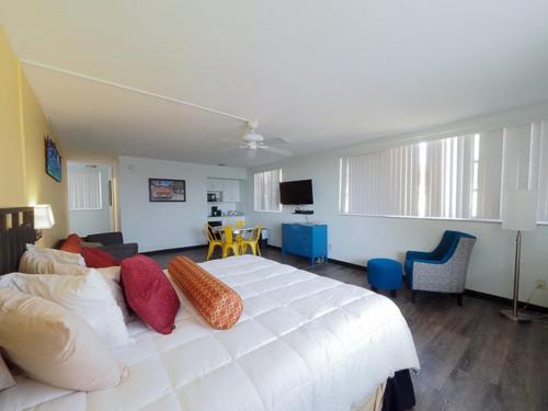 a bedroom with a large white bed and a living room at The Sands of Treasure Island in St Pete Beach