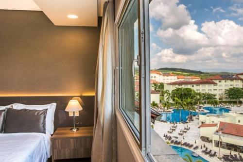 a bedroom with a view of a resort at Tauá Hotel & Convention Atibaia in Atibaia