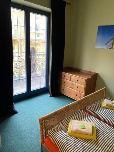 a bedroom with a bed and a dresser and a window at Apartments Merlin in Mariánské Lázně