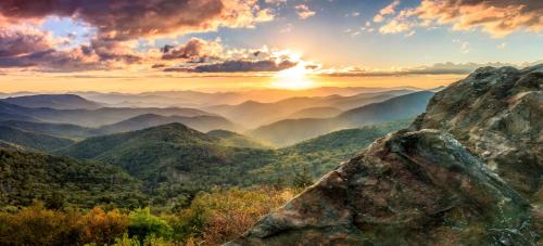 a view of a mountain range with the sun setting at Microtel Inn & Suites Dillsboro/Sylva in Dillsboro