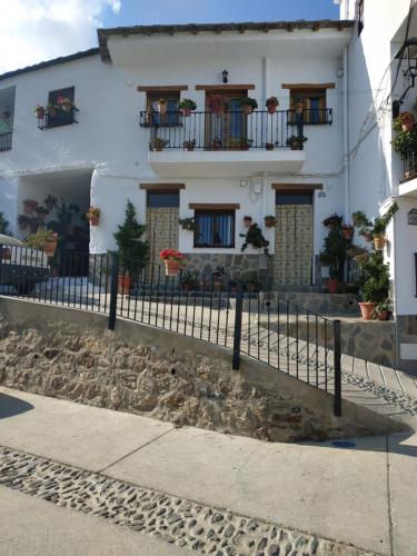een wit huis met balkons en een hek bij Casa rural el Mirador in Trevélez