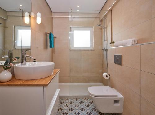 Casas Barulho Apartments Old Town في ألبوفيرا: حمام مع حوض ومرحاض