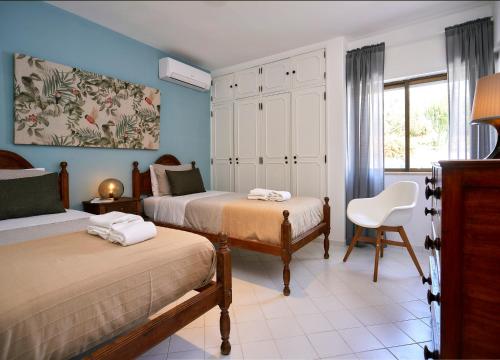 阿爾布費拉的住宿－Casas Barulho Apartments Old Town，一间卧室配有两张床和椅子