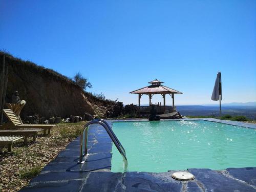 a swimming pool with a gazebo in the background at La Brizna "La tocas y te mueve" in Cañamero