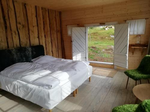 a bedroom with a bed and a large window at Eremitstuga Detox resort in Köpmannebro