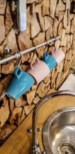 a bathroom with a sink and some cups on a wall at Kozma Apartments Peterlewand Gerlitzen Ossiachersee in Bodensdorf