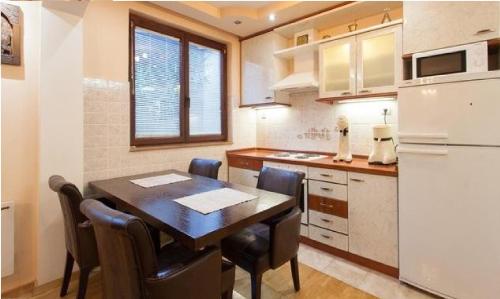 a kitchen with a table and chairs and a refrigerator at Apartments NOVEL town square in Ohrid