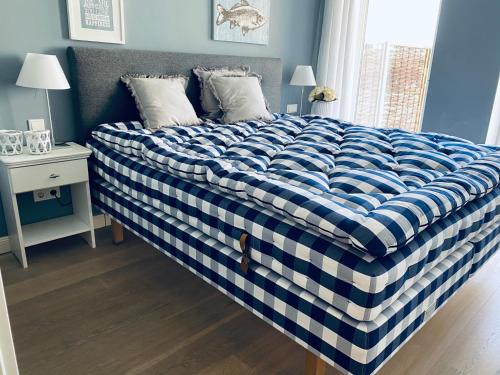 a bed with a blue and white checkered blanket at StrandHafen in Westerland