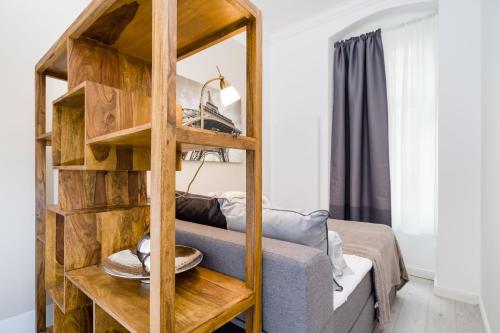 a living room with a wooden book shelf and a couch at GreatStay - Lohmeyerstr.13 HH. in Berlin