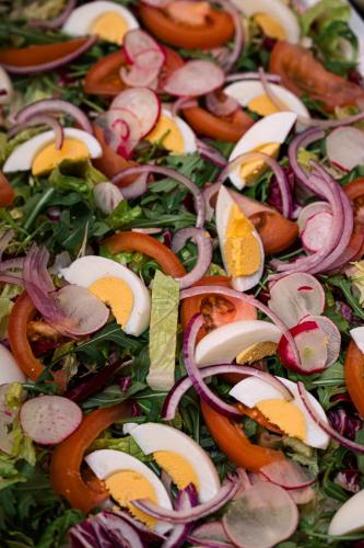 a close up of a salad with onions and other vegetables at Hotel Hamilton SPA & Wellness in Świnoujście