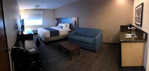 a hotel room with a bed and a blue chair at Best Western Mt. Hood Inn in Government Camp