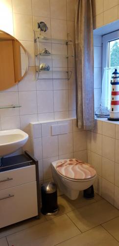 a bathroom with a toilet and a sink at Ferienwohnung Thees in Ummanz