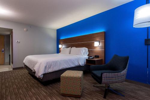 a hotel room with a bed and a chair at Holiday Inn Express Cape Coral-Fort Myers Area by IHG in Cape Coral