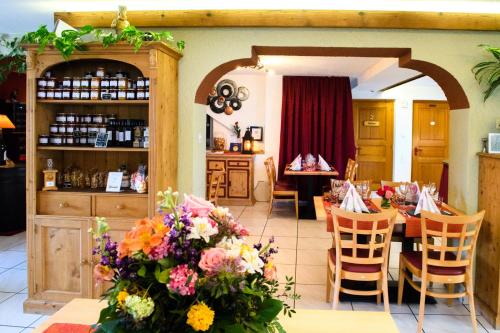 un restaurante con una mesa con flores. en Rêves Gourmands, Hôtellerie & Gastronomie, en Vernayaz