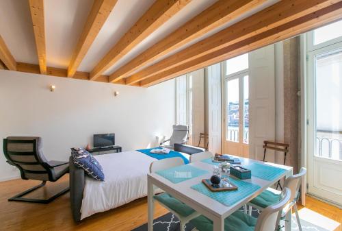 um quarto com uma cama, uma mesa e cadeiras em Monchique´s Balcony em Porto