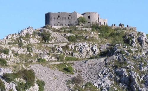 a castle on the side of a mountain at Apartmani Kosmac in Budva