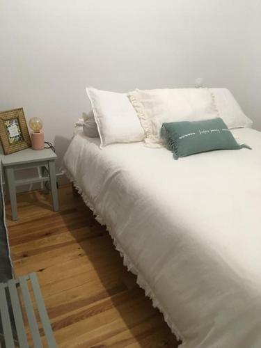 - un lit blanc avec deux oreillers et une table de chevet dans l'établissement Villa Framboise, à Lège-Cap-Ferret