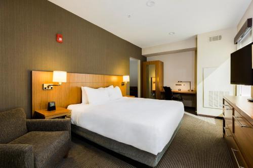 een hotelkamer met een groot wit bed en een bank bij Hyatt Place Augusta in Augusta