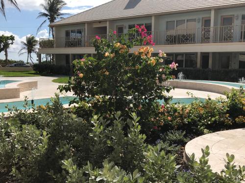 a house with a garden in front of a swimming pool at GetAways at Dover House Resort in Delray Beach