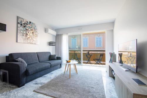 - un salon avec un canapé et une télévision dans l'établissement Near Croisette- 4 Star Studio -SeaView, à Cannes