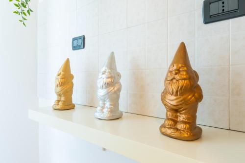 three statues of cats are sitting on a shelf at Marialuisa's Home - Le Rive Del Lago in Desenzano del Garda