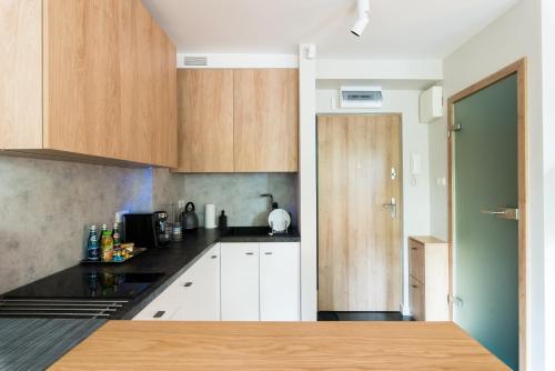 a kitchen with white cabinets and black counter tops at Apartament Solna - jedyny taki #Lublin in Lublin