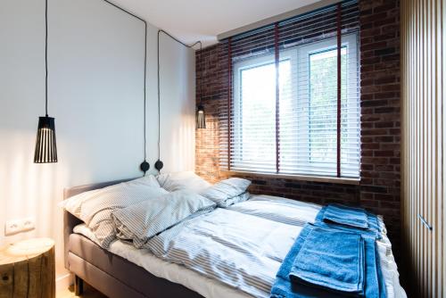 1 dormitorio con 1 cama con pared de ladrillo en Apartament Solna - jedyny taki #Lublin, en Lublin