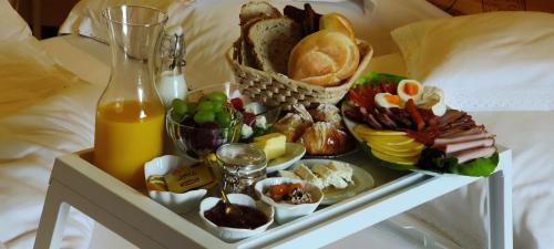 un vassoio di prodotti per la colazione su un letto di ECO Willa Grand Karpatia Ski&Wellness a Murzasichle