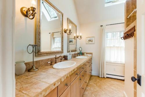 a bathroom with two sinks and a large mirror at Paradise On Cape Cod in Orleans