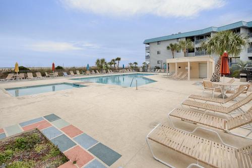 a swimming pool with lounge chairs and a hotel at As You Wish in Tybee Island