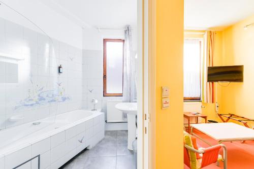 a bathroom with a white tub and a sink at Maison Dispa in Walcourt