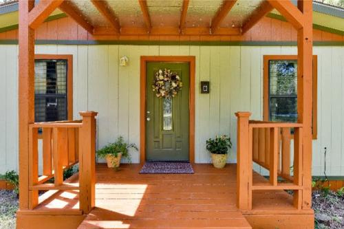 uma casa com uma porta verde e um alpendre em Austin Escape em Cedar Creek