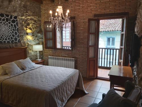 a bedroom with a bed and a brick wall at El Juacu in Llanes