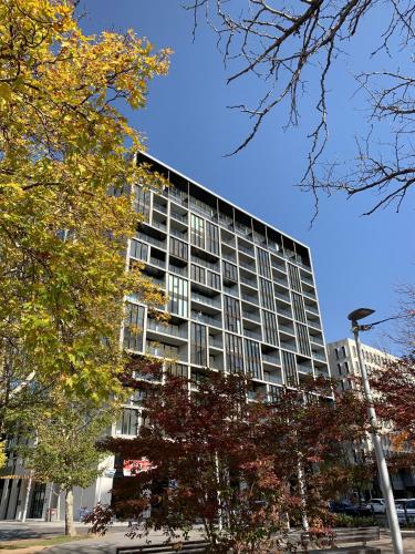 a tall building with trees in front of it at Capitol Executive Apartment on London Circuit in Canberra