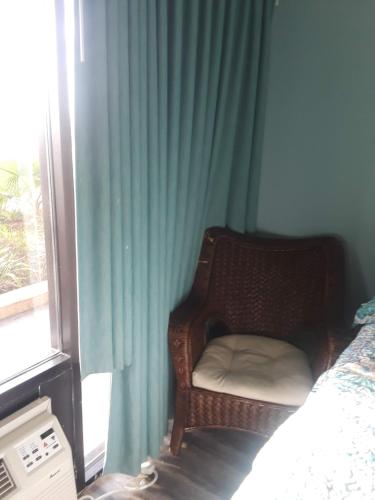 a bedroom with a chair next to a window at Benjamin's Pier at Laguna Reef Resort in Rockport