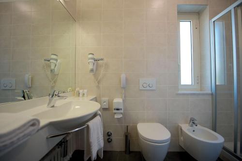 a bathroom with a sink and a toilet and a mirror at Best Western Hotel Luxor in Turin