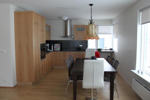 kuchnia i jadalnia ze stołem i krzesłami w obiekcie Akureyri Holiday Apartments w Akureyri