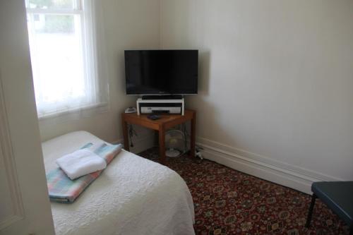 a bedroom with a bed and a television on a table at Taihape Motels in Taihape