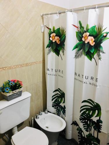 a bathroom with a toilet and a shower curtain at DLA Apartamentos III in Villa María