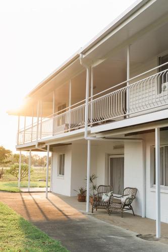 a white building with two chairs and a balcony at The Belle Riverhouse, Tumbulgum# in Tumbulgum