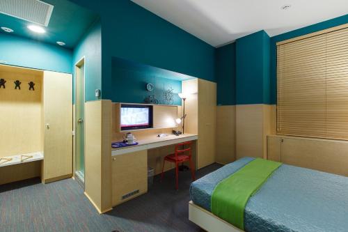 a bedroom with a bed and a desk with a television at Sleeport in Dnipro