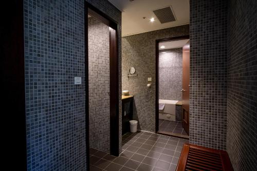 a bathroom with blue tile walls and a mirror at 柳營尖山埤 Liuying Jianshanpi Resort in Liuying