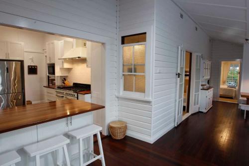 a kitchen with white walls and a wooden counter top at The Belle Riverhouse, Tumbulgum# in Tumbulgum