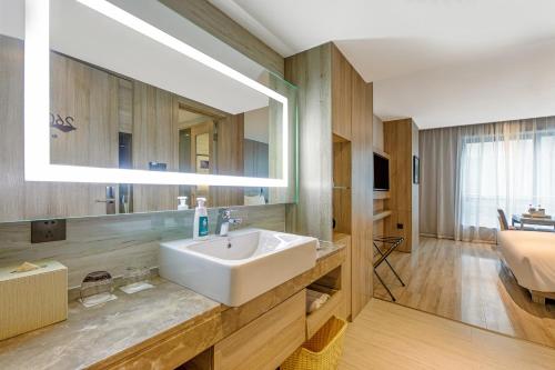 a bathroom with a sink and a large mirror at Atour Hotel Xi'an Gaoxin Branch in Xi'an