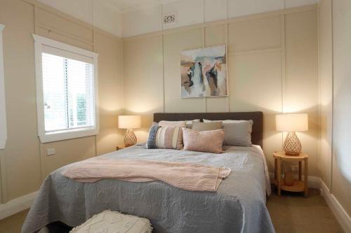 a bedroom with a large bed with two lamps at The Belle Riverhouse, Tumbulgum# in Tumbulgum