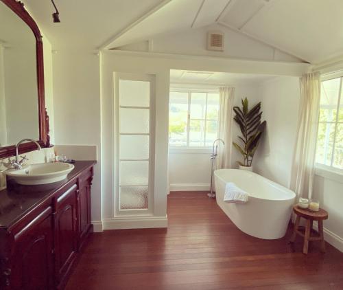 a bathroom with two sinks and a large tub at The Belle Riverhouse, Tumbulgum# in Tumbulgum