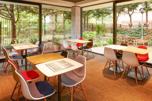 a classroom with tables and chairs and windows at ibis London Thurrock M25 in Grays Thurrock