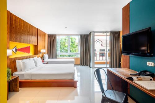 a hotel room with a bed and a desk with a computer at MeStyle Place Hotel in Bangkok